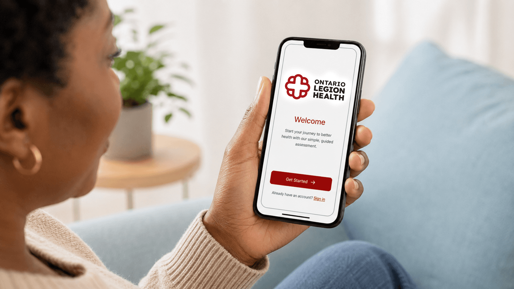 Person holding a phone with the OLH app at home